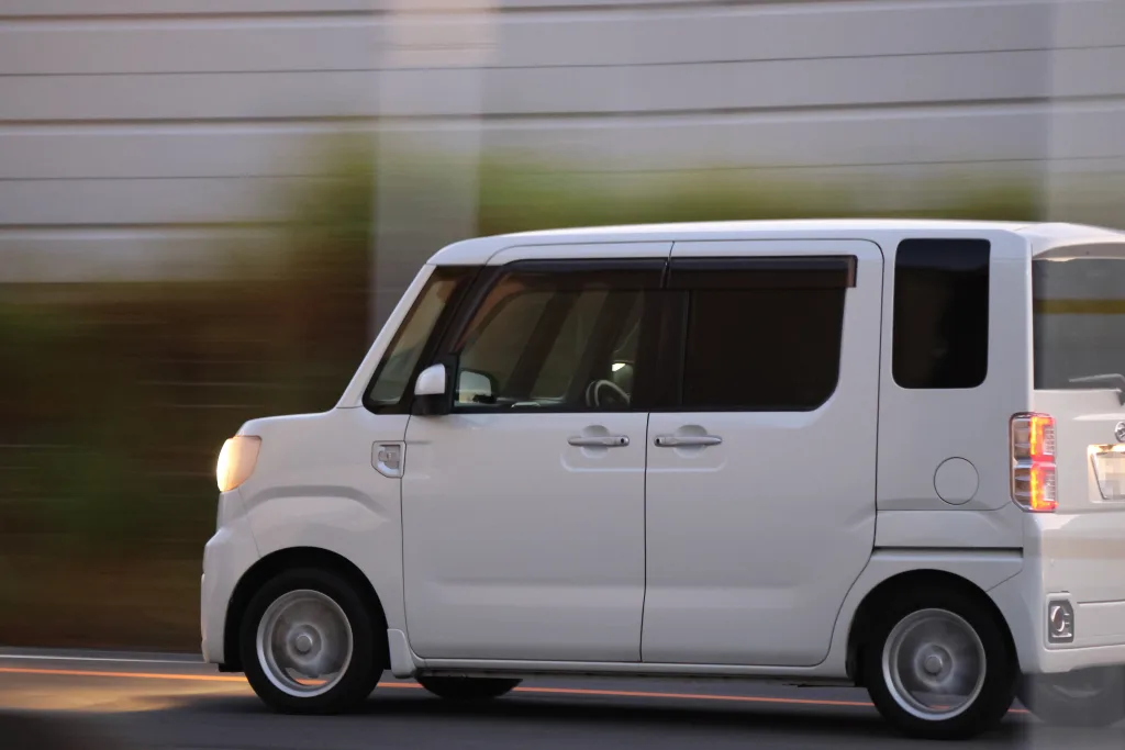 Canon R7と望遠ズームレンズで流し撮りした軽自動車の走行写真。