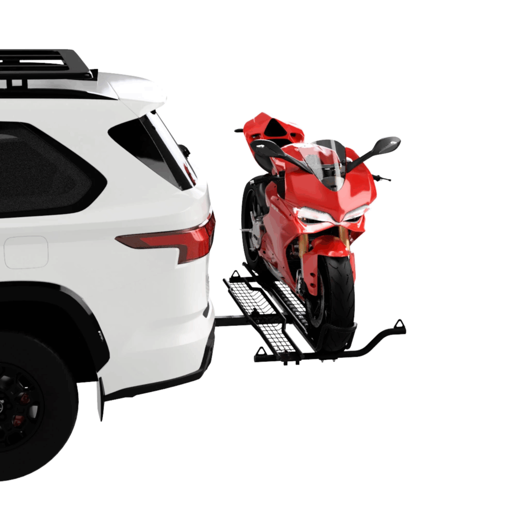 SUVのヒッチメンバーに取り付けられたMotoTote製バイクキャリアに赤いスーパースポーツバイクが固定されている様子
