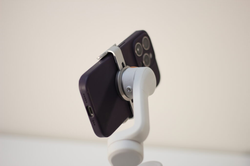 スマートフォンを取り付けた白いスマホ用ジンバル