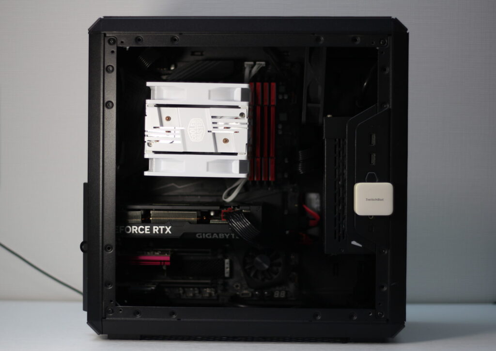 自作PCの内部構成。大型空冷CPUクーラー、GeForce RTX GPU、赤色のメモリモジュール、SwitchBot温度センサーが確認できる。