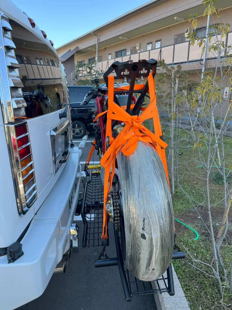ハマーH2に積載されたバイクのリアタイヤとタイダウンベルト