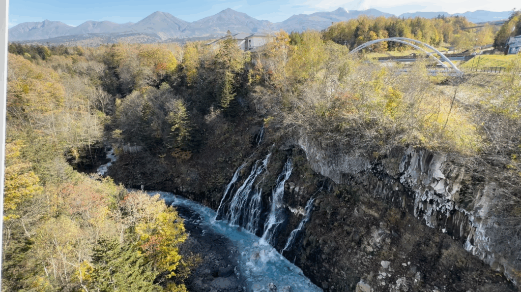 白ひげの滝と美瑛川、奥に十勝岳連峰を望む秋の絶景