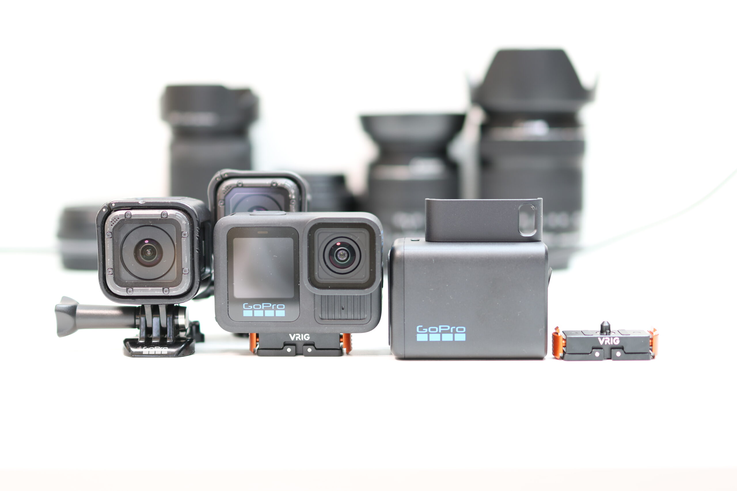 GoPro Hero SessionとHero13 Blackが並べられた構成。バッテリー、充電器、VRIGマウントパーツも含まれ、背景にはカメラレンズがぼかして配置されている。