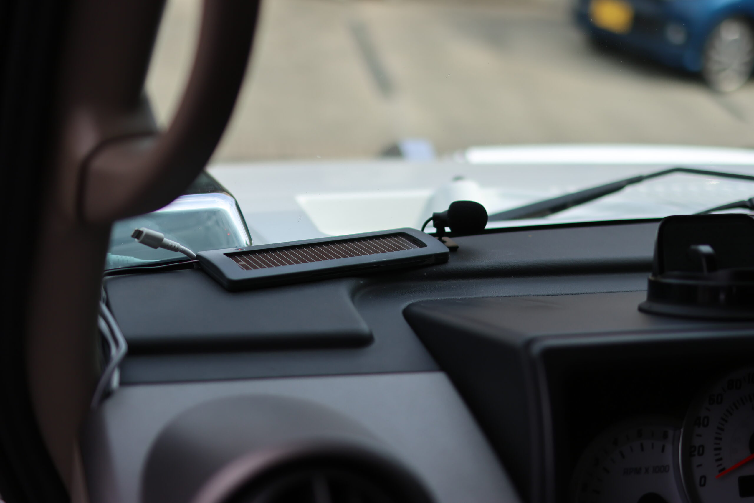 車のダッシュボードに設置された小型ソーラーパネルとマイク