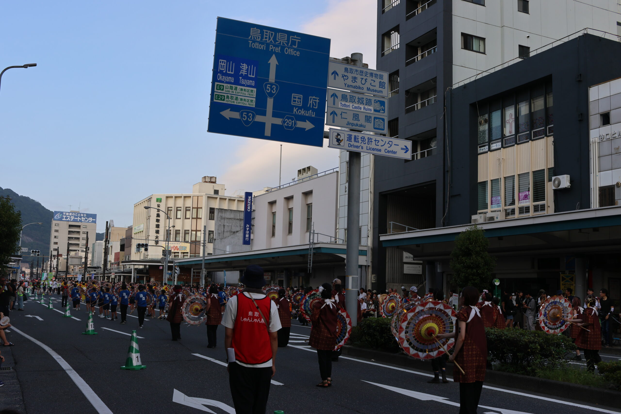 「しゃんしゃん祭りで傘踊りを披露する参加者たち（鳥取市中心市街地、鳥取県庁前）」