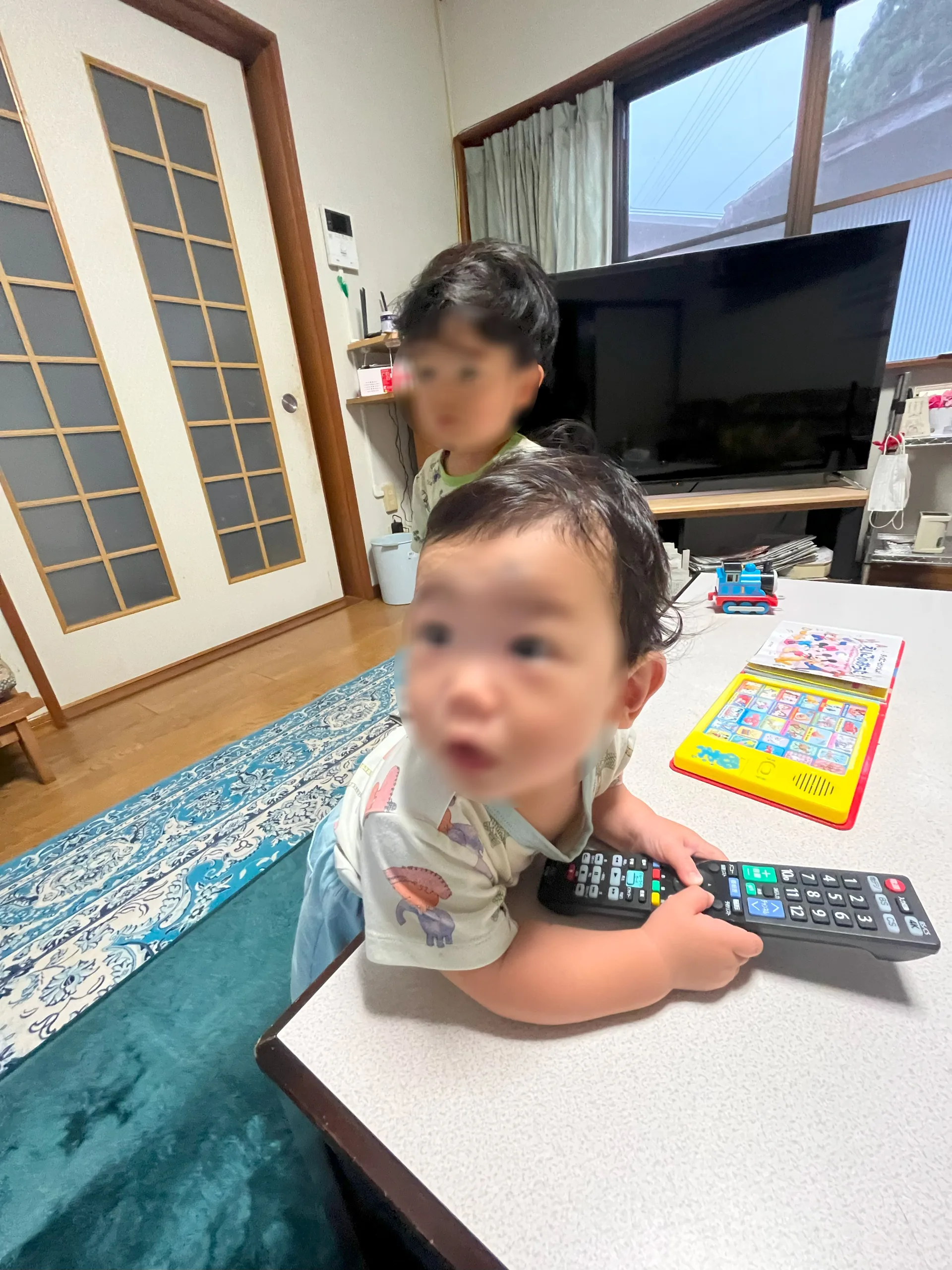 新しい引っ越しの話を聞いて驚いた表情を見せる幼い兄弟。