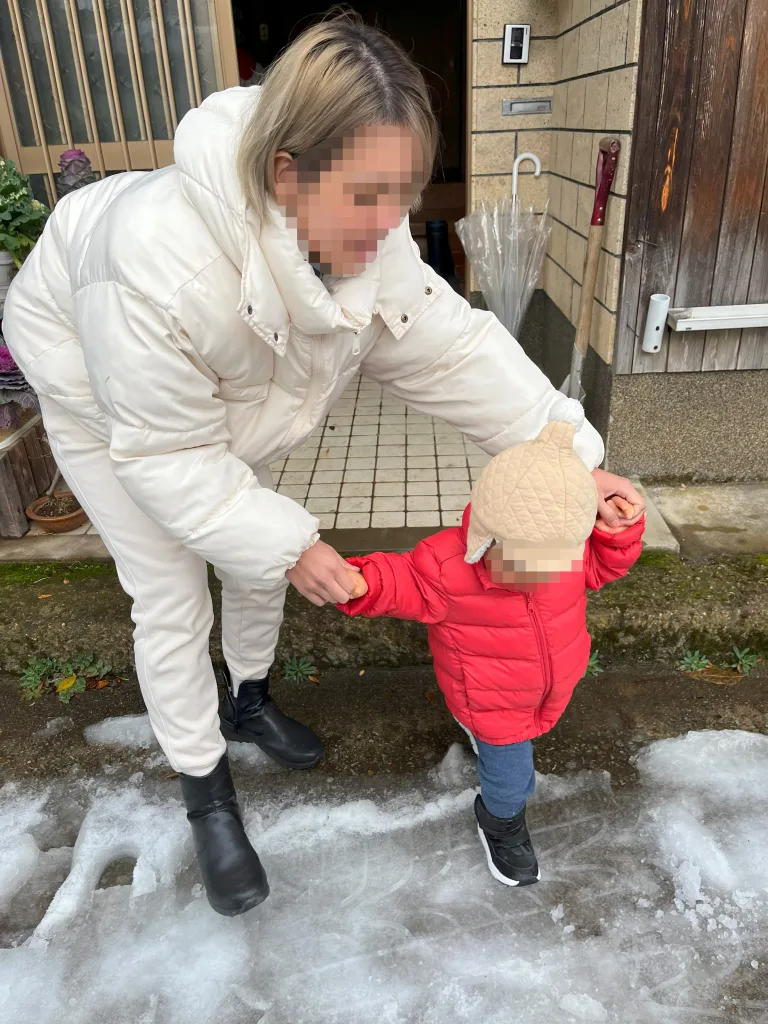 初めて凍結した雪の上を歩く子ども。慎重に足を運ぶ様子。