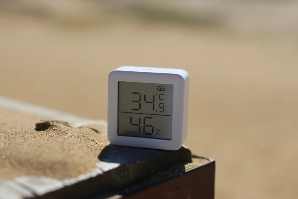 砂の上に置かれた温湿度計。表示は34.9℃、湿度46%。