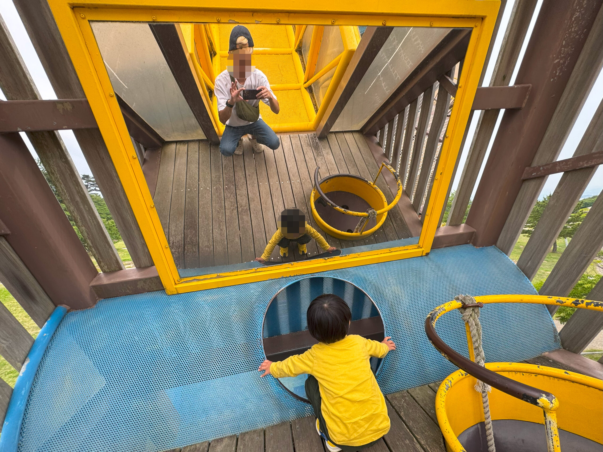 こどもの国のアスレチックで遊ぶ子どもと保護者の姿