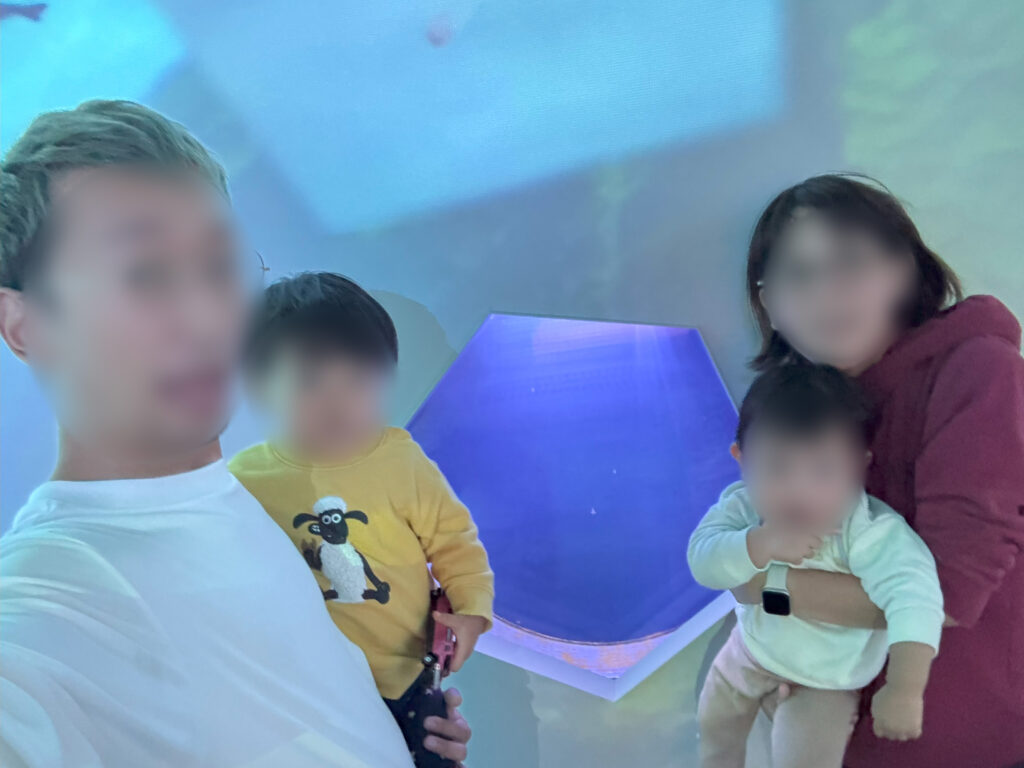 オホーツク流氷館でクリオネを背景に記念撮影する家族