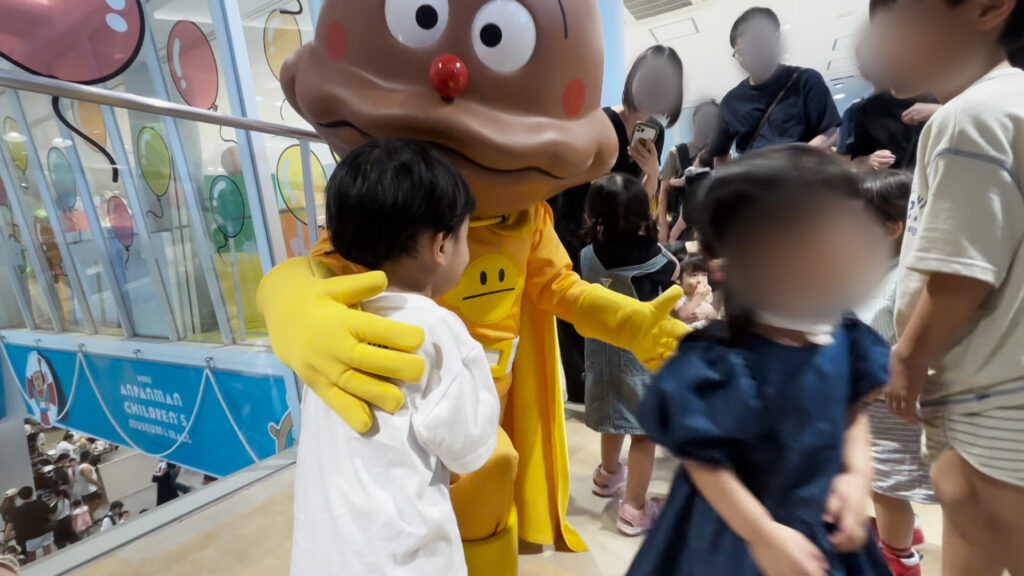 神戸アンパンマンミュージアムでカレーパンマンと触れ合う子ども