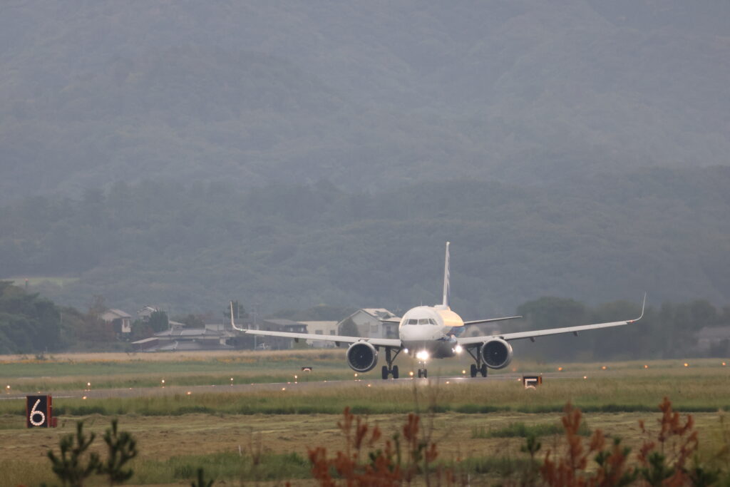 鳥取砂丘コナン空港の滑走路で離陸準備をする旅客機の写真