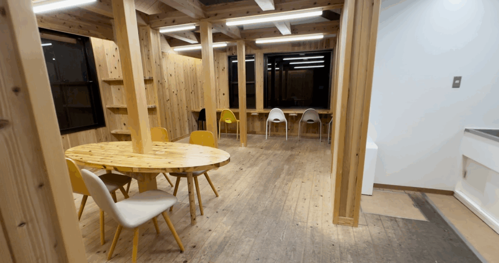 蒜山高原キャンプ場のトイレ内にある木目調の休憩スペース。テーブルと椅子が配置された清潔な空間