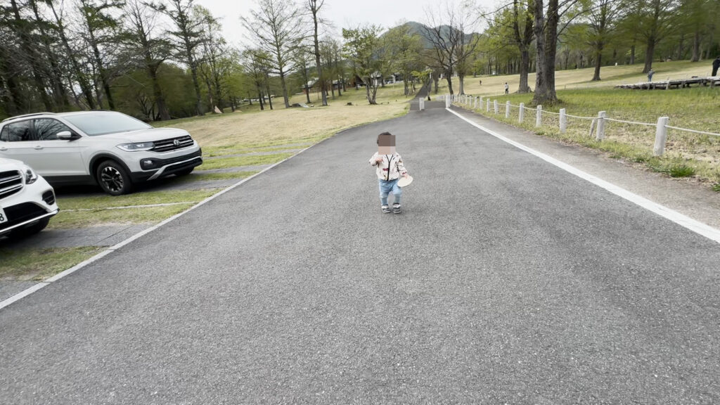 蒜山高原キャンプ場の通路を歩く幼児。広々とした芝生と整備された道路が特徴のキャンプ場