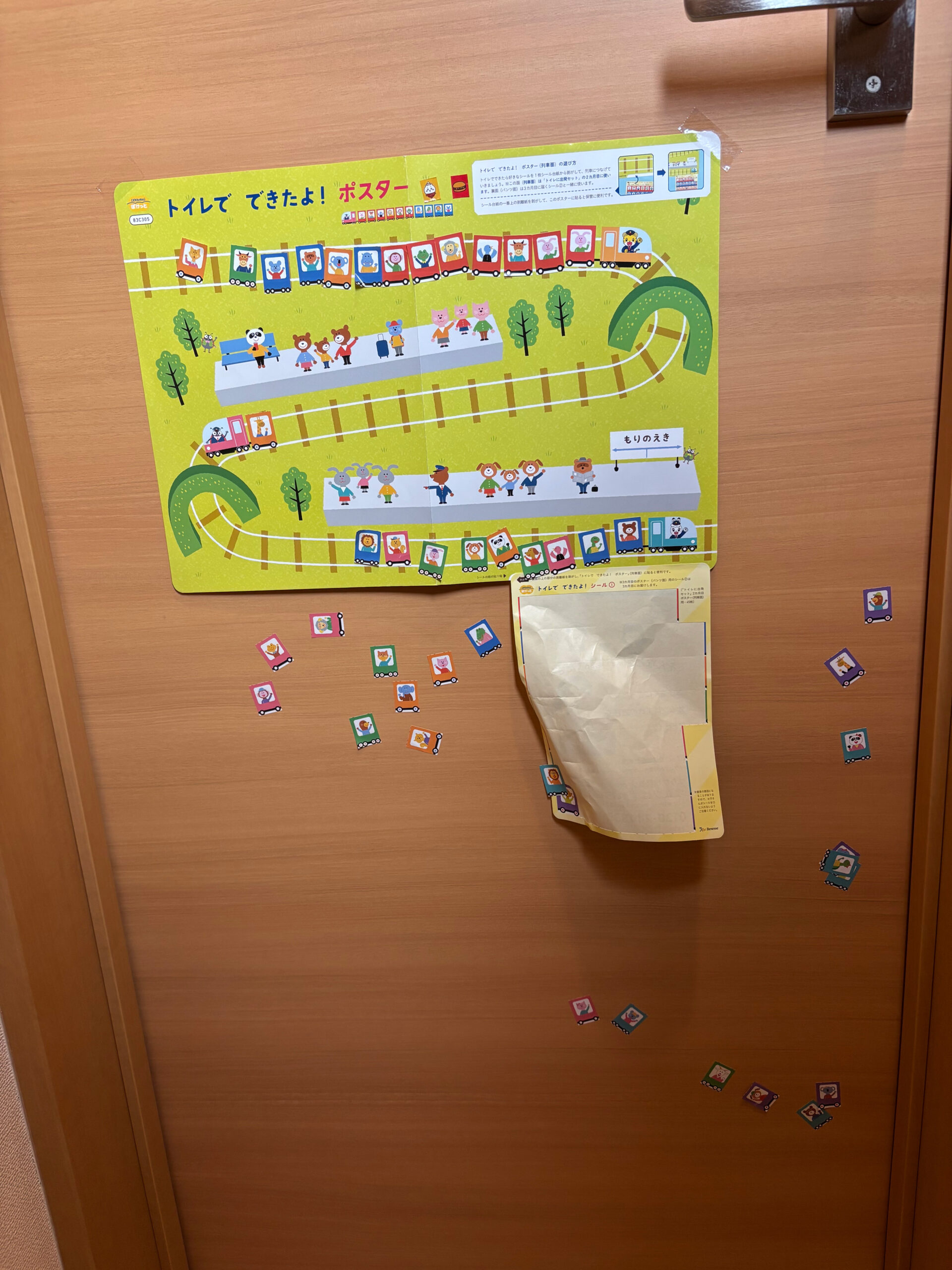 トイレトレーニング用のご褒美シールポスターとドアに貼られたシール